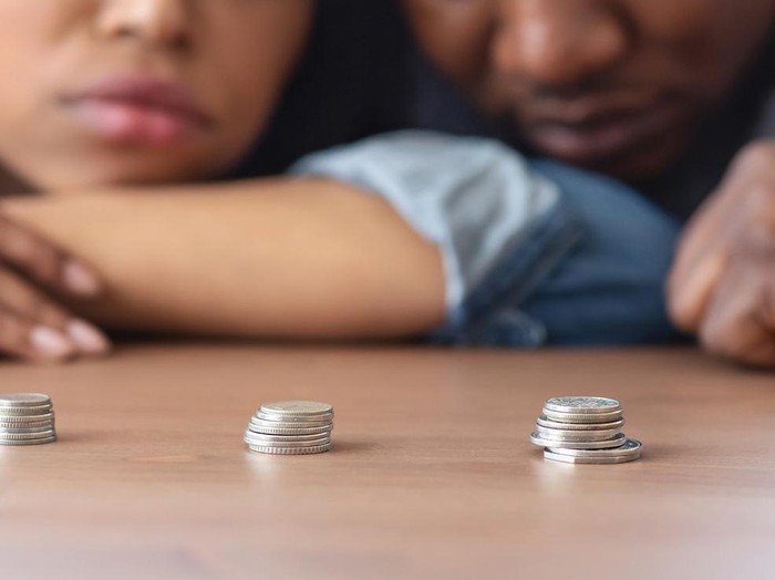 Ilustrasi Suami-Istri Miskin Poverty And Absence Of Money Concept. Stacks Of Coins Lying On Table In Front Of Sad African American Couple, Crop