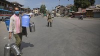 Tentara dan polisi mendatangi rumah-rumah penduduk dan memperingatkan mereka untuk tetap berada di rumah. (Mukhtar Khan/AP)