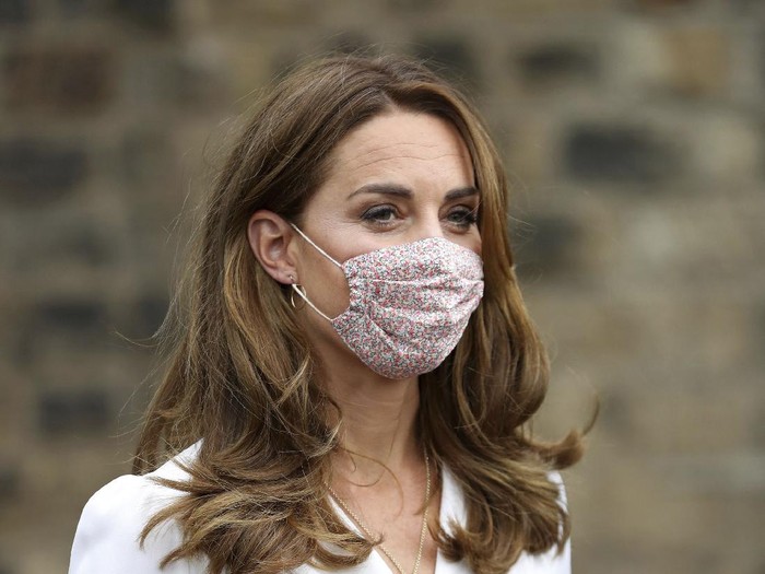 Britains Kate, the Duchess of Cambridge, wears a face mask to protect against coronavirus, as she talks to parents Ali Wartty and Sahara Hamawandy about their triplets San, Shan and Laveen, during a visit to Baby Basics Sheffield, in Sheffield, England, Tuesday, Aug. 4, 2020. Baby Basics is a volunteer led project which supports families in need struggling to provide for their newborns. (Chris Jackson/PA via AP)