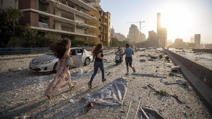 Kepanikan dan Evakuasi Korban Ledakan di Libanon Lebanese man helps an injured man who was wounded by an explosion that hit the seaport, in Beirut Lebanon, Tuesday, Aug. 4, 2020. (AP Photo/Hussein Malla)