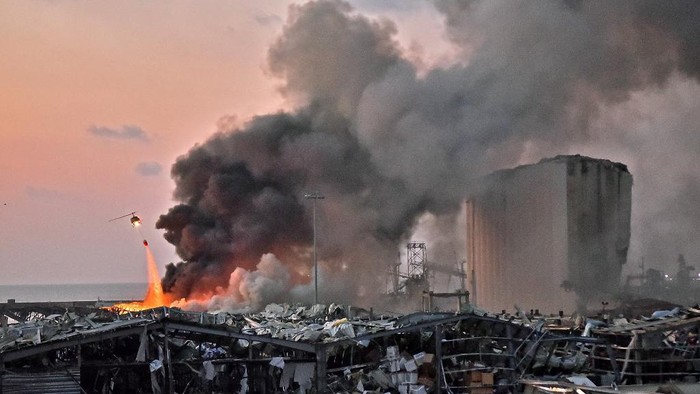 LEBANON-BLAST EDITORS NOTE: Graphic content / A helicopter puts out a fire at the scene of an explosion at the port of Lebanons capital Beirut on August 4, 2020. (Photo by STR / AFP)