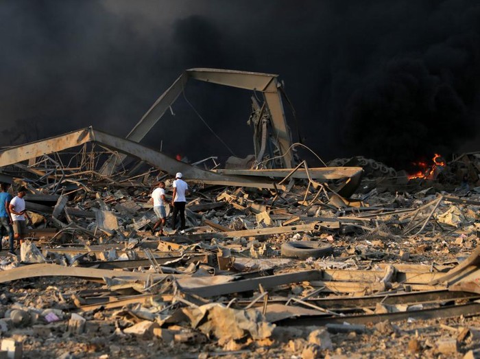 EDITORS NOTE: Graphic content / A helicopter puts out a fire at the scene of an explosion at the port of Lebanons capital Beirut on August 4, 2020. (Photo by STR / AFP)