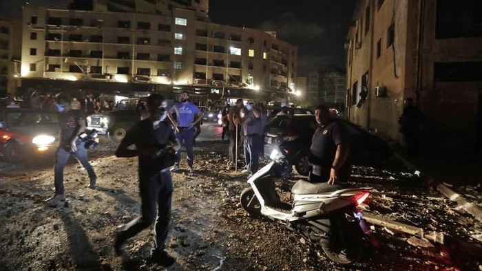 EDITORS NOTE: Graphic content / A helicopter puts out a fire at the scene of an explosion at the port of Lebanons capital Beirut on August 4, 2020. (Photo by STR / AFP)