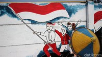 Mural bergambar sejumlah warga sedang mengibarkan bendera merah putih.