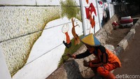 Mural bergambar area persawahan yang menghijau juga menghiasi dinding di kawasan Jalan Pangeran Komarudin, Cakung, Jakarta Timur.