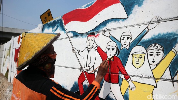 Pasukan Oranye Percantik Ibu Kota dengan Mural Kemerdekaan Petugas PPSU Kelurahan Cakung Timut menghiasi dinding dengan gambar di Jalan Pangeran Komarudin, Cakung, Jakarta Timur, Rabu (5/8/2020). Menjelang kemerdekaan Agustusan PPSU menghiasi dinding kota dengan gambar tema kemerdekaan guna memperindah kota.