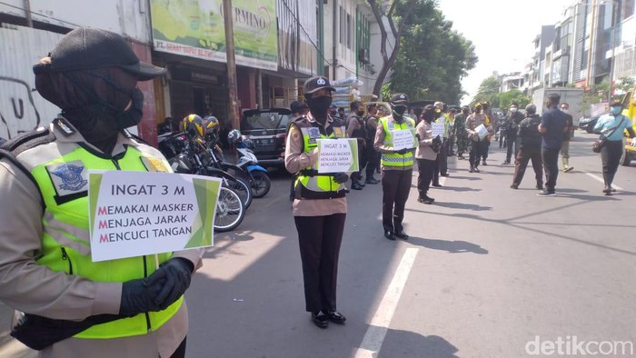 Pihak kepolisian Tanjung Perak terus mengimbau masyarakat agar menerapkan protokol kesehatan. Polisi membagikan masker bagi mereka yang tidak menggunakan.