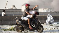 Dengan sepeda motor, warga mengevakuasi korban yang terluka. AP Photo/Hassan Ammar.