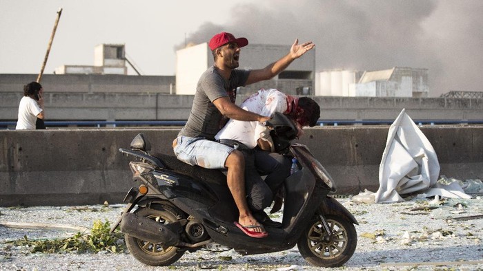 Injrued are evacuated after a massive explosion in Beirut, Lebanon, Tuesday, Aug. 4, 2020. Massive explosions rocked downtown Beirut on Tuesday, flattening much of the port, damaging buildings and blowing out windows and doors as a giant mushroom cloud rose above the capital. Witnesses saw many people injured by flying glass and debris. (AP Photo/Hassan Ammar)