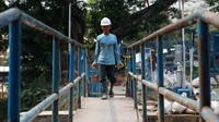 Seorang pekerja mengangkut material untuk revitalisasi Setu Parigi.