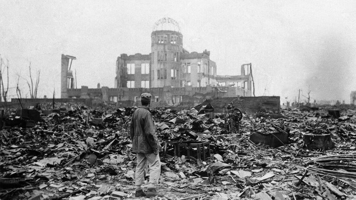 FILE - In this Sept. 8, 1945, file photo, an allied correspondent stands in a sea of rubble before the shell of a building that once was a movie theater in Hiroshima, western Japan, a month after the first atomic bomb ever used in warfare was dropped by the U.S. to hasten Japans surrender. Many people exposed to radiation developed symptoms such as vomiting and hair loss. Most of those with severe radiation symptoms died within three to six weeks. Others who lived beyond that developed health problems related to burns and radiation-induced cancers and other illnesses. (AP Photo/Stanley Troutman, Pool, File)