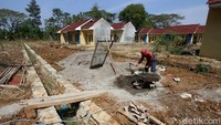 Pekerja sedang mengaduk semen dan pasir untuk membangun rumah bersubsidi.