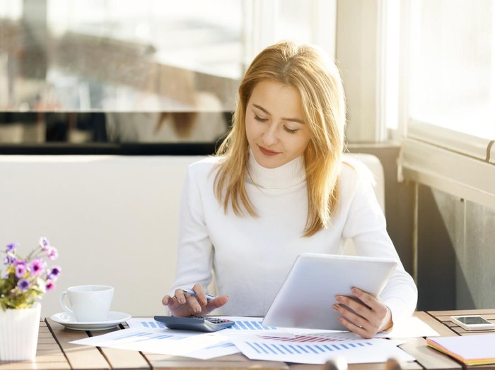 Ilustrasi menghitung uang Businesswoman using Tablet