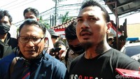 Jerinx hadir dengan mengenakan celana hitam dan kaus hitam bertulisan Indonesia Tolak Rapid. 