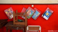 Buku-buku para siswa mengantung di dinding kelas. Semenjak pandemi COVID-19, buku tersebut belum tersentuh oleh siswa karena aktivitas belajar dihentikan untuk sementara waktu. 