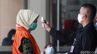 Desi harus dicek suhu tubuhnya sebelum memasuki gedung KPK.