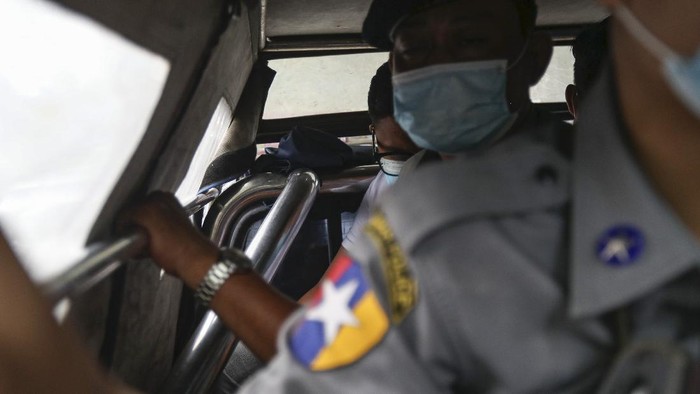 Canadian pastor David Lah, rear,  is escorted by police to a township court for a hearing Thursday, Aug. 6, 2020, in Yangon, Myanmar. The court have sentenced Lah to three months imprisonment after finding him guilty of violating a law intended to combat the spread of the coronavirus. (AP Photo/Thein Zaw)
