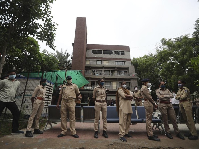 Police officers stand guard outside Shrey hospital, where a fire broke out early morning in Ahmedabad, India, Thursday, Aug. 6, 2020. Firefighters and 15 fire engines contained the fire to the intensive care unit at Shrey Hospital and it was extinguished in half an hour, fire officer Yusuf Khan said. (AP Photo/Ajit Solanki)