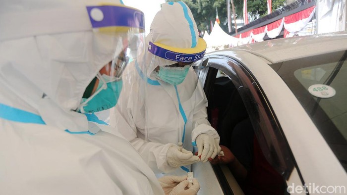 Rapid Test Drive Thru Petugas kesehatan menegambil sample darah warga yang mengikuti rapid test di Depan Kejaksaan Agung, Jakarta, Kamis (6/7/2020). Kejaksaan Agung menggelar tes cepat massal. Tes diikuti para pengendara ataupun pejalan kaki yang melintas kawasan tersebut dalam upaya pencegahan covid-19.