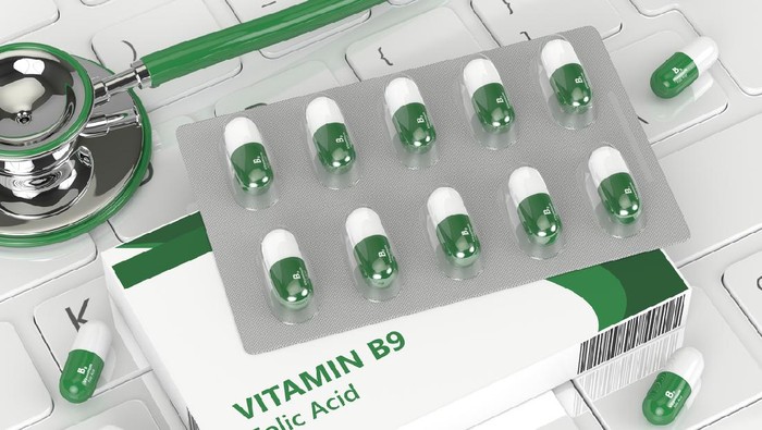 3d render of B9 folic acid pill  lying on keyboard in office