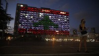 Gedung kotamadya diterangi dengan bendera Lebanon di Tel Aviv, Israel. AP Photo/Sebastian Scheiner  