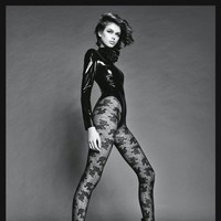 Foto berikutnya memperlihatkan Kaia berpose dengan bodysuit kulit dan stocking lace yang memamerkan kaki jenjangnya. (Foto: dok. Vogue Japan)