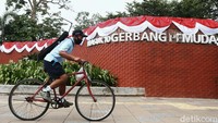 Pesepeda melintas di kawasan GBK yang penuh ornamen HUT RI.