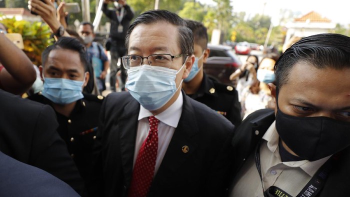 Former Finance Minister and Penang chief minister Lim Guan Eng, center, is escorted by Anti Corruption officers as he arrives at courthouse in Kuala Lumpur, Malaysia, Friday, Aug. 7, 2020. Lim was arrested last night to be charged with corruption in connection with the Penang undersea tunnel project, the Malaysian Anti-Corruption Commission (MACC). (AP Photo/Vincent Thian)