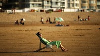Seorang wanita berjemur saat musim panas di pantai Zoute di Knokke-Heist, Belgia utara. AP Photo/Francisco Seco  