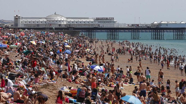 Para pengunjung pantai menikmati sinar matahari dan laut saat hari terpanas di Inggris. AP Photo/Alastair Grant Para pengunjung pantai menikmati sinar matahari dan laut saat hari terpanas di Inggris. AP Photo/Alastair Grant