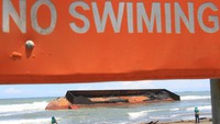 Warga melihat kapal tongkang pengangkut batu bara yang terdampar di Kawasan Pantai Naga Permai Desa Gampong Lhok, Kecamatan Kuala Pesisir, Nagan Raya, Aceh, Jumat (7/8/2020).