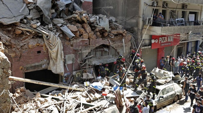 Civil defense ambulances from the Lebanese Shiite Muslim political party Hezbollah, enter the site of the explosion that hit the seaport of Beirut on Tuesday, to help in the rescue effort, in Beirut, Lebanon, Thursday, Aug. 6, 2020. Lebanese officials targeted in the investigation of the massive blast that tore through Beirut sought to shift blame for the presence of explosives at the citys port, and the visiting French president warned Thursday that without serious reforms the country would 