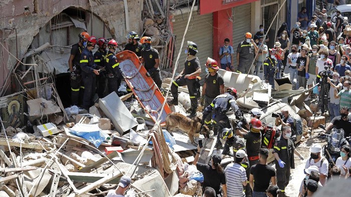 Pencarian Korban Ledakan di Lebanon Terus Dilakukan Civil defense ambulances from the Lebanese Shiite Muslim political party Hezbollah, enter the site of the explosion that hit the seaport of Beirut on Tuesday, to help in the rescue effort, in Beirut, Lebanon, Thursday, Aug. 6, 2020. Lebanese officials targeted in the investigation of the massive blast that tore through Beirut sought to shift blame for the presence of explosives at the city's port, and the visiting French president warned Thursday that without serious reforms the country would
