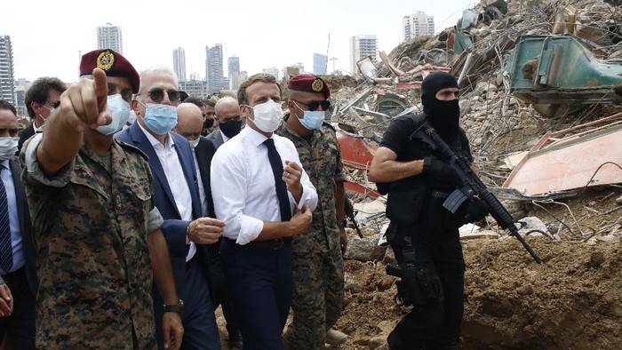 French President Emmanuel Macron, center, visits the devastated site of the explosion at the port of Beirut, Lebanon, Thursday Aug.6, 2020. French President Emmanuel Macron has arrived in Beirut to offer French support to Lebanon after the deadly port blast.(AP Photo/Thibault Camus, Pool)
