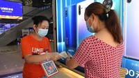 Pemeriksaan suhu tubuh juga dilakukan kepada pengunjung. Foto: Dok. Xinhua/Peng Ziyang