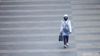 Seorang pekerja melintas di kawasan Sudirman, Jakarta, Jumat (7/8/2020).