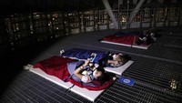 Wisatawan memakai masker wajah saat menginap di area berkemah semalam di atap gedung pencakar langit di Seoul, Korea Selatan.