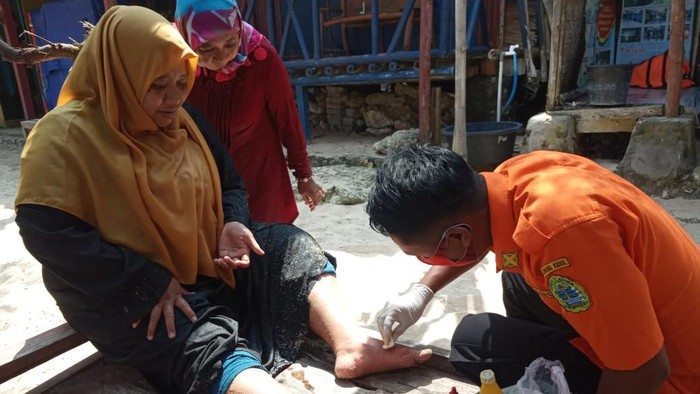 Anggota SAR Satlinmas Wilayah II Kabupaten Gunungkidul saat memberikan pertolongan kepada wisatawan yang tersengat ubur-ubur