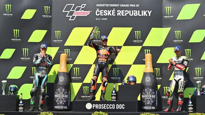 (L-R) Second placed Petronas Yamaha SRTs Italian rider Franco Morbidelli, winner Red Bull KTM Factory Racings South African Brad Binder and third placed Esponsorama Racings French rider Johann Zarco celebrate on the podium after the Moto GP Czech Grand Prix at Masaryk circuit in Brno on August 9, 2020. (Photo by Joe Klamar / AFP)