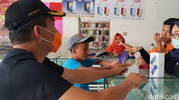 Catur Ferianto (16) pelajar yang jadi kuli tampak sibuk memilih smartphone, Sabtu (8/8/2020)