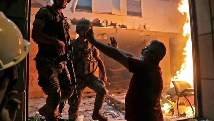 Lebanese soldiers try to extinguihs the flame at the headquarters of the Lebanese association of banks in downtown Beirut on August 8, 2020, following a demonstration against a political leadership they blame for a monster explosion that killed more than 150 people and disfigured the capital Beirut. (Photo by ANWAR AMRO / AFP)