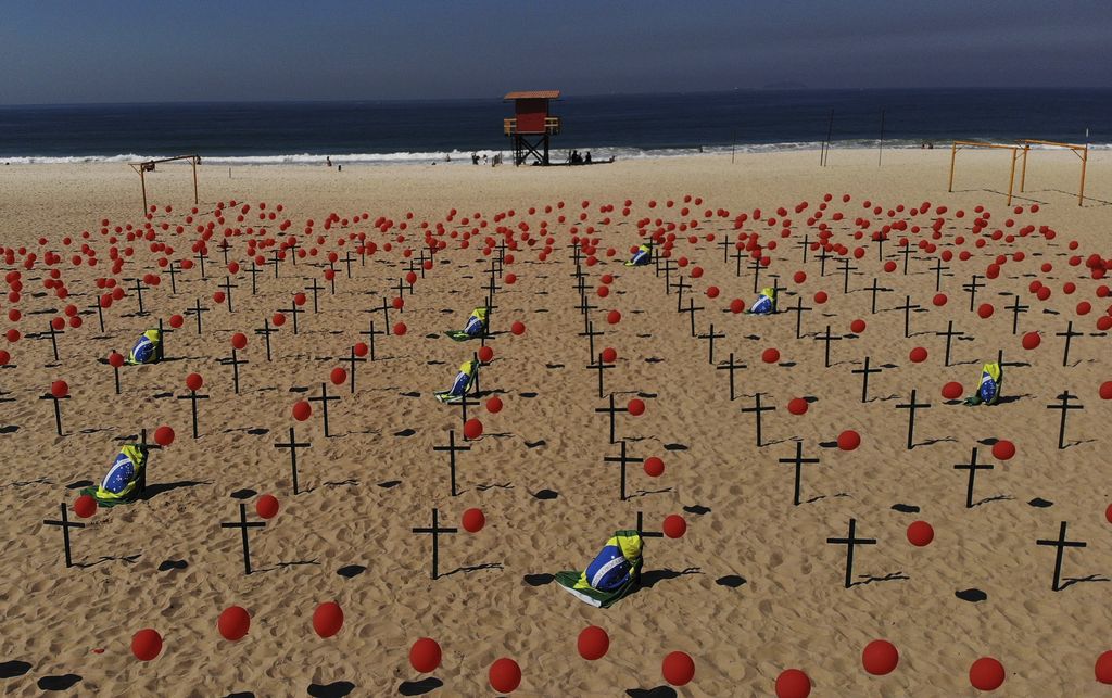 100 ribu kematian karena virus corona di Brazil. AP/Mario Lobao Crosses and red balloons are placed in the sand on Copacabana beach in a demonstration organized by Rio de Paz to honor the victims of COVID-19, as the country heads to a milestone of 100,000 new coronavirus related deaths, in Rio de Janeiro, Brazil, Saturday, Aug. 8, 2020. (AP Photo/Mario Lobao)