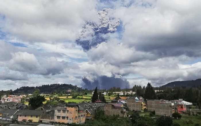 Indonesia Volcano Indonesian men use their mobile phones to take photos as Mount Sinabung spews volcanic materials into the air as it erupts, in Karo, North Sumatra, Indonesia, Monday, Aug. 10, 2020. The rumbling volcano erupted Monday, sending a column of volcanic materials a few thousands meters into the sky. Sinabung is among more than 120 active volcanoes in Indonesia, which is prone to seismic upheaval due to its location on the Pacific