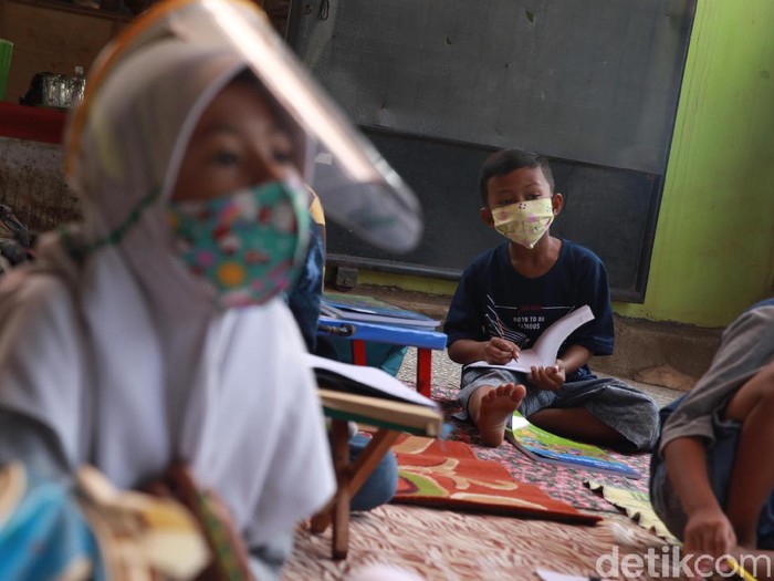 Murid kelas IV SD Muhammadiyah 37 belajar pada teras rumah seorang guru di kawasan Pondok Cabe Udik, Tangerang Selatan, Banten, Senin (10/8/2020). Kegiatan belajar mengajar (KBM) tatap muka dengan menerapkan standar protokol kesehatan ini terpaksa dilakukan karena murid kesulitan menguasai materi pelajaran saat proses belajar secara online.