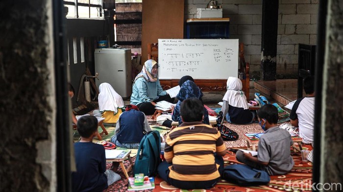 Murid kelas IV SD Muhammadiyah 37 belajar pada teras rumah seorang guru di kawasan Pondok Cabe Udik, Tangerang Selatan, Banten, Senin (10/8/2020). Kegiatan belajar mengajar (KBM) tatap muka dengan menerapkan standar protokol kesehatan ini terpaksa dilakukan karena murid kesulitan menguasai materi pelajaran saat proses belajar secara online.