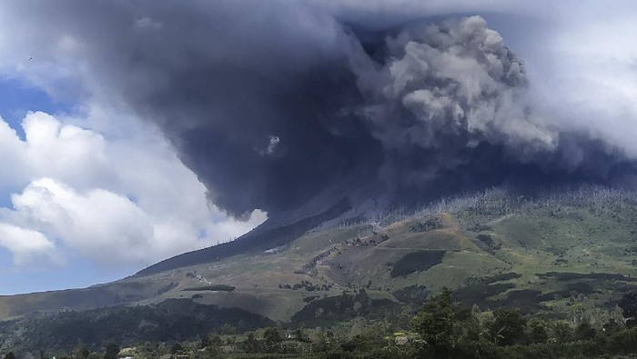 Sejumlah kendaraan melintas di jalan yang dipenuhi debu vulkanik pasca erupsi Gunung Sinabung, di Desa Sigarang-garang, Karo, Sumatera Utara, Sabtu (8/8/2020). Gunung Sinabung erupsi dengan tinggi kolom 2.000 meter. ANTARA FOTO/Sastrawan Ginting/Lmo/hp.