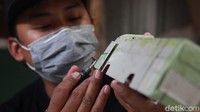 Dengan teliti dia membuat miniatur bus.