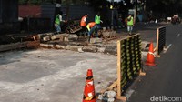 Sejumlah pekerja dan alat berat melakukan perbaikan jalan tersebut.