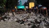 Jalan yang rusak dikelupas dengan alat berat.