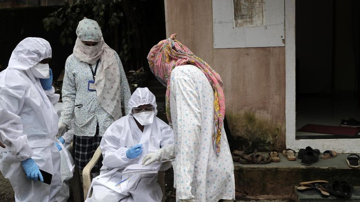 A health worker waits to take nasal swab samples to test for COVID-19 at a medical camp in Mumbai, India, Saturday, Aug. 8, 2020.As India hit another grim milestone in the coronavirus pandemic on Friday, crossing 2 million cases and more than 41,000 deaths, community health volunteers went on strike complaining they were ill-equipped to respond to the wave of infection in rural areas. (AP Photo/Rajanish Kakade)